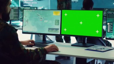 Ordu subayı, askeri komuta merkezinde uydu radar görüntüleri ve yeşil ekran kullanıyor. İstihbarat toplamak ve düşman gemilerini tespit etmek için çalışıyor. Hükümet teşkilatının komutanı. Kamera A.
