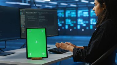 İş yükleri için bilgisayar kaynakları sağlayan sunucu odasındaki idari programlamanın yanındaki izole ekran tabletine odaklan. Veri merkezi süper bilgisayarlarını denetleyen işçilerin kullandığı masada krom anahtar aygıtı