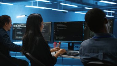 Yüksek teknoloji sunucu merkezinde çalışan çok ırklı mühendisler veri analizi için bilgisayarları kullanıyor. Veri merkezindeki altyapıyı inceleyen, sistem bütünlüğü ve güvenliğini sağlayan çok ırklı bir çalışan grubu