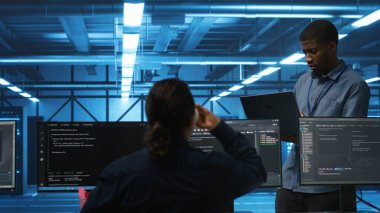 Sunucu merkezindeki bilişim teknisyenlerinin veri depolama ekipmanlarını tamir etme müdürü. Veri merkezinde çalışan takım lideri, hesaplama işlemleri yapan tırları tamir eden işçilere nezaret ediyor.