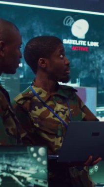 Dikey video ordu komutanları güvenlik kameralarına kayıtlı gerçek zamanlı verilerle saha operasyonlarını denetliyor. Askeri yetkililer görev detaylarını inceliyor. Güç üssündeki ordu savunma programı.