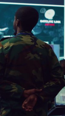 Dikey video ordu subayı, ulusal güvenliği sağlamak için istihbarat toplayan, keşif için büyük ekrandaki uydu güvenlik görüntülerini inceliyor. Gizli Servis Federal Ajansı