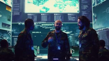 Donanma operasyon uzmanları, bir hologram vasıtasıyla gözetleme radarlarını izliyorlar. Bir askeri kontrol merkezinde üç boyutlu çizimler üzerinde çalışıyorlar. Generallerden oluşan bir ekip istihbarat topluyor. Kamera B.