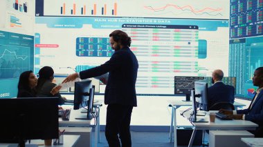 Finans müdürü ekip üyelerine yeni şirket hedefleri hakkında brifing vererek bütçe planlarını harcamalarla sunuyor. Kaynak tahsisi ve proje planlaması kontrol odasında. Kamera B.