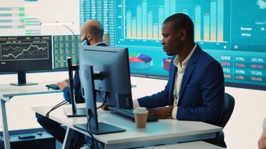 Ekibine istatistik broşürlerini gösteren memnun bir genel müdür. Örgütsel faaliyetleriyle gurur duyuyor. Müdür, satış raporlarını incelemek için iş arkadaşlarıyla toplantı yapıyor. Kamera A.