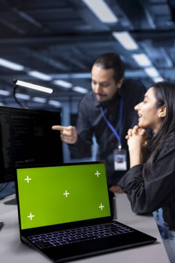 Bulanık arka planda sistem yöneticileri tarafından süper bilgisayarları denetlemek için kullanılan izole ekran laptopuna odaklan. Sunucu merkezi kurulumunda IT uzmanı tarafından kullanılan kroma anahtar defterinin yakın plan görüntüsü