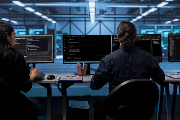 Computer operators in data center running system diagnostic tests to do repairments. IT specialists at PC desk in server room deploying error checking utilities to fix network issues