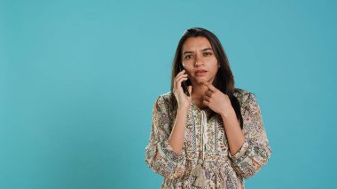 Hintli bir kadın arkadaşlarıyla telefonda konuşuyor. Akıllı telefon kullanıyor. Stüdyoda izole edilmiş. Telefon görüşmesi sırasında eşiyle tartışan kişinin portresi, kamera A