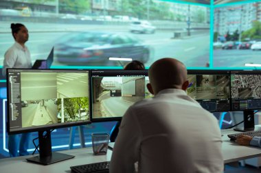 Ortadoğulu adam birden fazla ekrandaki trafik kamerası görüntülerini denetliyor. Gözlem odasındaki radar aktivitelerini izliyor. CCTV 'de plaka okumalarıyla ilgilenen bir ekip..