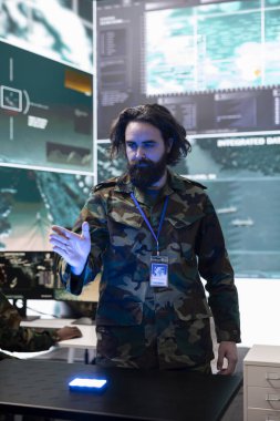 Ordu askeri, bir hologram 3D projeksiyonunun gerçek zamanlı verilerini inceleyerek askeri kontrol odasındaki savunma operasyonlarını gözden geçirir. Asker, 3D görüntülemedeki CCTV uydu görüntülerine bakıyor..