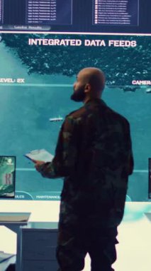 Askeri güç üssündeki gerçek zamanlı uydu verilerini inceleyen dikey video ordu subayı düşman gemilerinin yörüngeleri hakkında istihbarat topluyor. Federal savunma programı uzmanı.