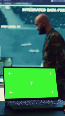 Dikey Video Kumandanı, askeri komuta merkezinde, ordu keşif bölümündeki bir yeşil ekranı inceliyor. Operatör sahadan istihbarat topluyor, gerçek zamanlı veri aktarıyor. Kamera.