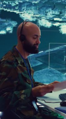 Dikey video askeri operatörü düşman gemilerinin GPS koordinatlarını ulusal muhafızlara gönderiyor, güvenlik kameralarından gerçek zamanlı veri sağlıyor. Ordu subayı güç üssü kontrolünde çalışıyor.