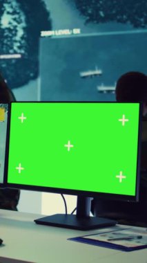 Dikey video istihbarat analisti, kıyı limanları boyunca demirleyen gemilerin GPS koordinatlarını takiben izole edilmiş bir model ekranın yanında gemi faaliyetlerini inceliyor. Ordu subayı izleme odasında.