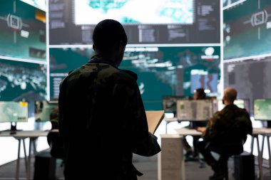 Askeri komuta merkezinde istihbarat toplama faaliyetlerini denetleyen piyade birliği askeri. Dava dosyaları ve büyük ekran arasındaki verileri karşılaştırıyor. Ordu, uydu bilgilerini inceliyor..