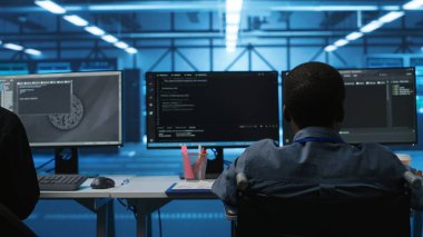 Bilgisayarda veri merkezinde çalışan çok ırklı iş arkadaşlarının yanında engelli biri var. Tekerlekli sandalye kullanıcısı ve çok ırklı ekip birlikte çalışıyor, programlama yapıyor, sunucu kümelerini denetliyor