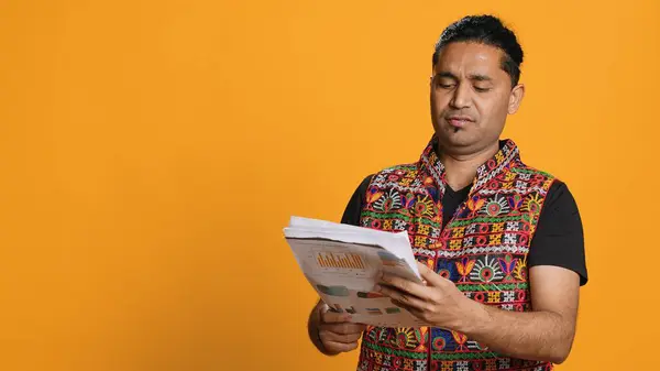 stock image Irked manager looking over company financial profit report audit, disappointed by results, isolated over studio background. Mad indian man throwing business documents in frustration, camera A