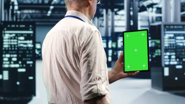 Stock image Technician in high tech data center using green screen tablet to monitor energy efficient servers using renewable sources employed to minimize consumption and reduce overall facility carbon footprint