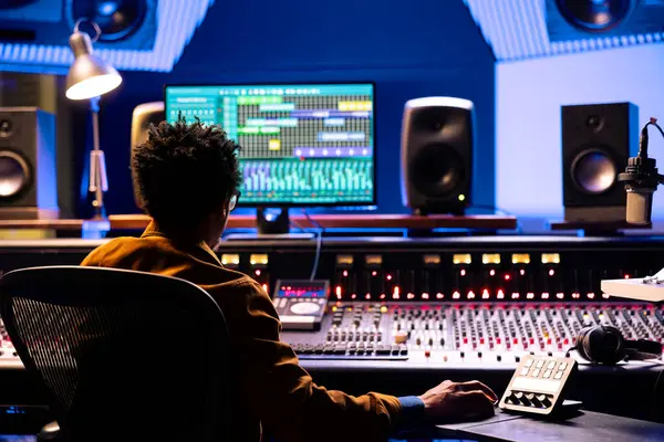 Müzik yapımcısı, kontrol odasında ses konsolu ve bilgisayardaki profesyonel yazılımla sesleri düzenliyor ve işliyor. Üretim mühendisi motorlu faders ve çevirme düğmeleri kullanıyor.