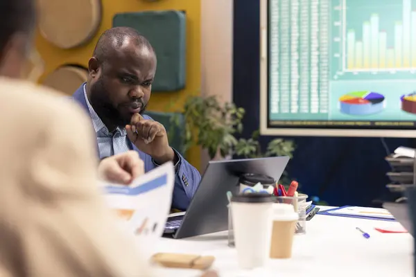 Stock image Organizational team gathering in a conference room to review sales on interactive board, increasing organizational capital and profit. PR specialists ensuring international success and productivity.