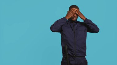 Bina yöneticiliği yaparken baş ağrısından muzdarip yorgun güvenlik görevlisinin portresi. Özel güvenlik görevlileri yorgunluk, stüdyo arkaplanı, kamera B