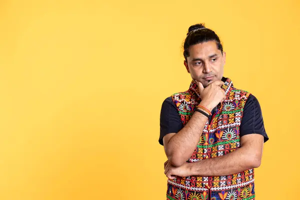 stock image Pensive Indian man deep in thoughts, doing ruminating hand gesturing, isolated over studio background. Unsure person doing stroking chin gesture, thinking, studio backdrop