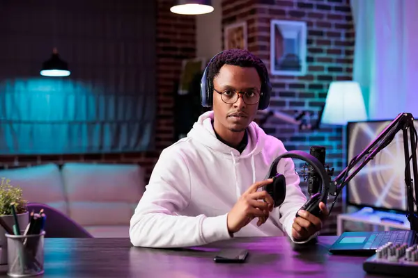 stock image Portrait of gadgets reviewer internet celebrity recording show episode using professional microphone in living room studio. Content creator filming technology channel vlog in rgb lights home