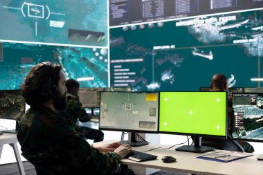 Profesyonel bilişim mühendisi güvenlik görüntülerine ve izole edilmiş modellere bakıyor, savunma operasyonları programı için federal CCTV bilgileriyle çalışıyor. Askerler ulusal güvenliğe yardım ediyor.