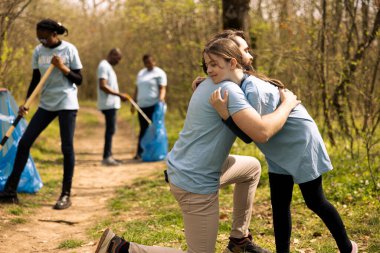 Tatlı çocuk, birlikte ağaç diktikten sonra babasını kucaklıyor. Gönüllü işlerinden mutlu ve memnun. Mutlu baba ve küçük çocuk kucaklaşıyorlar, başarılı birliktelik..