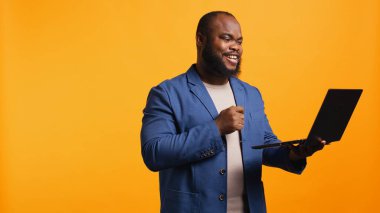 Çalışan, toplantı sırasında iş arkadaşıyla konuşurken el hareketi yapmaz. Dizüstü bilgisayarını, stüdyo geçmişini kullanır. Anlaşmazlık işareti gösteren kişi, video çağrısı sırasında protesto fikri, kamera B