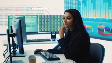 Hintli satış müdürü şirket ortak çalışma alanındaki bilgi grafiklerini doğruladı, iş stratejileri ve hedefleri oluşturmaya çalışıyor. Çalışan piyasa dinamiklerini ve büyük verileri inceliyor. Kamera A.