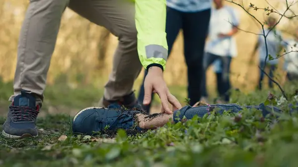 stock image Rescuers group finding murdered barefoot victim in the forest, scared people calling the police. Mysterious horror manslaughter in the woods, civilians found a dead body, grim murder. Camera A.