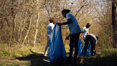 Afrika kökenli Amerikalı bir kız uzun pençe ve çöp torbalarıyla çöp topluyor, orman habitatını temizliyor ve bir grup gönüllüyle yasadışı çöplerle savaşıyor. Çöpleri toplayan aktivist. Kamera B.