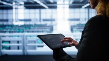 Sistem yöneticisi veri merkezi ekipman ömrünü uzatmak için tablet kullanarak yıllık check-up yapıyor. Bilgi işlem uzmanının dijital aygıt, kamera B kullanarak süper bilgisayarları izleme görüntüsünü kapat