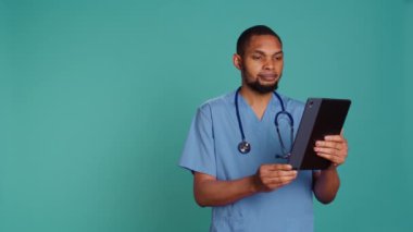 Video konferansında keyifli bir doktor tablet kullanarak, tedavi sağlayarak. İnternet teletıp kontrolü sırasında hasta sorunlarını dinleyen neşeli bir sağlık uzmanı.