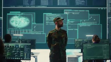 Yüksek teknoloji ofisindeki hükümet hackleme faaliyetlerini denetleyen resmi askeri görevli büyük ekrandaki verilere bakıyor. Ağ güvenliği, şifreleme ve siber terörizmin önlenmesi üzerinde çalışıyorum. Kamera B.