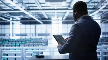 Sunucu merkezindeki teknisyen yeni sipariş edilen depolama ünitesini kuruyor, parametreleri tabletle kontrol ediyor. Veri merkezi tutma aygıtı bilişim uzmanı, depolama ana bilgisayarlarının bileşenlerinin değiştirilmesi, kamera B