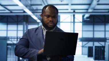 Veri merkezindeki bilgisayar bilimcisi, hata nedenlerini tespit etmek için dizüstü bilgisayardaki tanısal araçları ve sistem izleme yazılımını kullanıyor. Bilgi İşlem Uzmanı: Sunucu Çiftliği Onarım Ekipmanları, Kamera A