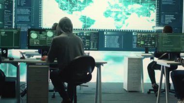 Melez savaşı sırasında dijital güvenlik faaliyetleri üzerinde çalışan hükümet hackerlarıyla birlikte siber operasyonlar merkezi. Uzmanlar güvenlik ve kötü amaçlı yazılım tespiti ve siber gözetim sağlıyorlar. Kamera A.