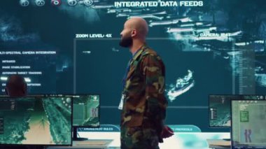 Karmaşık askeri operasyonlar için ordusunu koordine eden Korgeneral, her birimin yeni bir ulusal güvenlik görevi hakkında senkronize ve bilgilendirilmesini sağlıyor. Komuta merkezi. Kamera A.