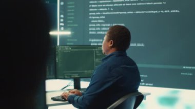 Siber savunma ekibi bir hükümet güvenlik operasyon merkezinde çalışıyor. Uzmanlar siber suçları önleme ve veri sızıntısı korumasını güvence altına alarak büyük ekranda bilgi inceliyorlar. Kamera A.