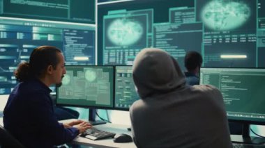 Devletin hackleme odasındaki siber güvenlik uzmanları ağları güvence altına almak için çalışıyorlar. Bilgisayar korsanları kötü amaçlı yazılım tespiti, siber operasyonlar ve dijital paralı askerlere karşı koruma üzerinde çalışıyorlar. Kamera B.