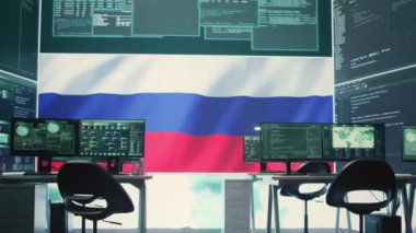 Büyük ekranda Rus bayrağı olan hükümet siber operasyon odası bilgi savaşı ve trollemeye odaklanıyor. Hackerların yanlış bilgilendirme ve kalabalığı kontrol etmedeki rolünü vurgulamak. Kamera B.