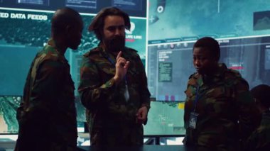 Ordu subayları yeni görev için bir özet oluşturmak amacıyla önemli saha bilgisi topladıktan sonra operasyonel planlar yapmak amacıyla bir hologramla ilgili verileri gözden geçiriyorlar. Yüksek teknoloji holografik görüntü. Kamera A.