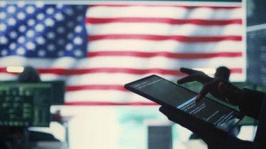 Siber güvenlik uzmanı Amerikan bayrağıyla birlikte devletin bilişim alanında. Siber tehditlere karşı korunmak için bir tablette siber güvenlik, şifreleme ve veri güvenliğinin izlenmesi. Kapatın. Kamera B.