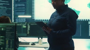 Yüksek teknoloji ofisindeki bilgisayar ağında çalışan hükümet hackerları veri güvenliği ve siber operasyonlara odaklanıyorlar. Siber suçlar, veri koruması ve güvenli ortamda tehdit tespit etme. Kamera A.