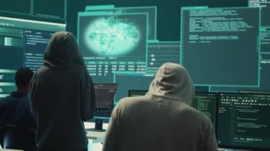 Yüksek teknoloji ofisindeki veri tabanına ve sunuculara erişemeyen hükümet hackerlarından oluşan hayal kırıklığına uğramış ekip melez savaş şifrelerini çalmak için büyük ekranla çalışıyor. Hüsrana uğramış uzmanlar. Kamera A.