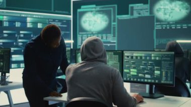 Hükümet hackerları hassas bilgileri dijital paralı askerlerin siber tehditlerinden korumak için takım çalışması yapıyorlar. Uzmanlar çevrimiçi güvenlik ve siber savunma taktiklerine odaklanıyor. Kamera B.