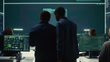 Siber güvenlik ekibi bir hükümet kontrol odasında siber gözetleme yapıyor. Uzman grup hackleme faaliyetleri, kötü amaçlı yazılım koruması ve yüksek teknoloji ajansında veri sızıntısını önleme. Kamera B.
