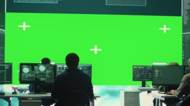 Hükümet hackerlarından oluşan bir ekip, yüksek teknoloji bürosundaki yeşil ekrana bakıyorlar. Siber savaş faaliyetleri için veritabanı sistemlerini hacklemek için birlikte çalışıyorlar. Yasadışı dolandırıcılık yapan uzmanlar. Kamera A.